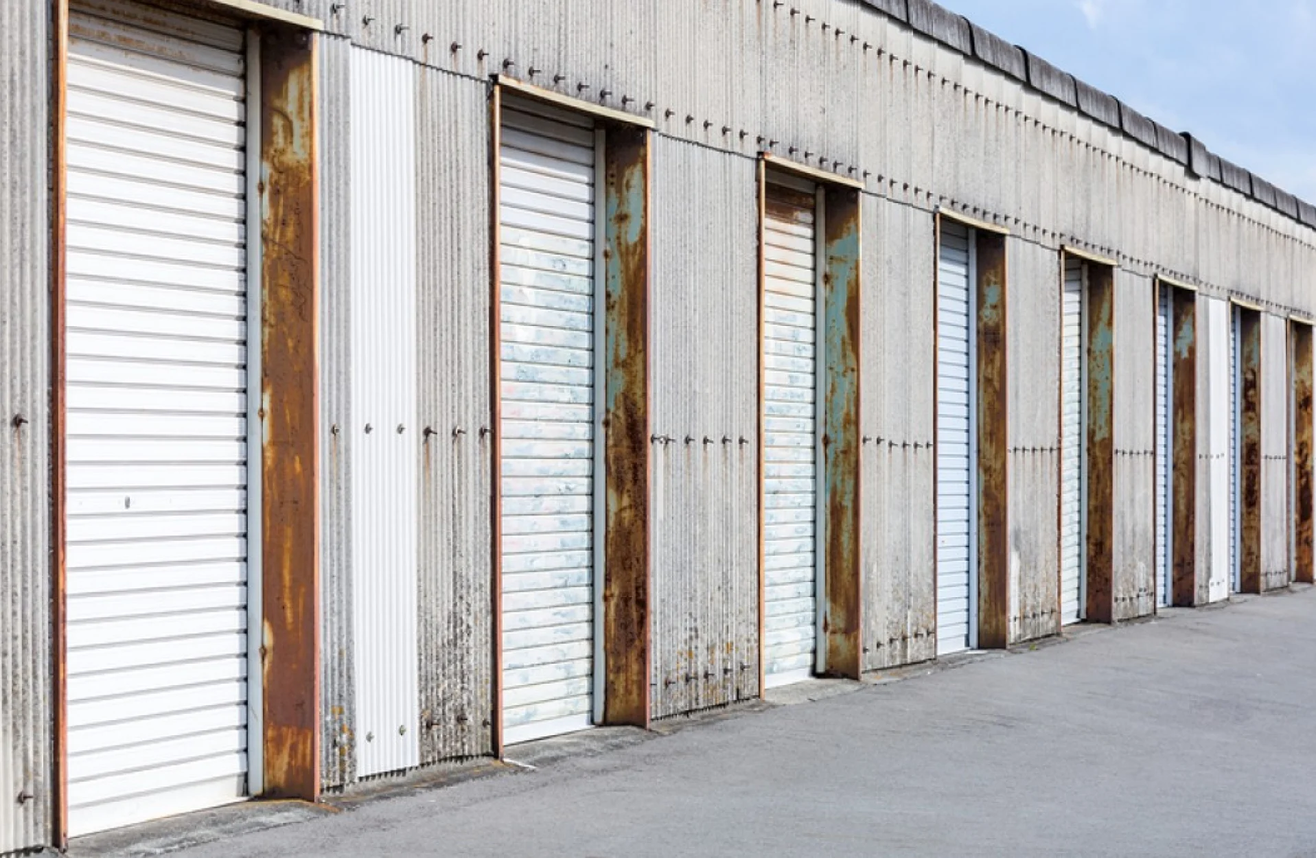 A long row of storage units with corrugated metal doors
